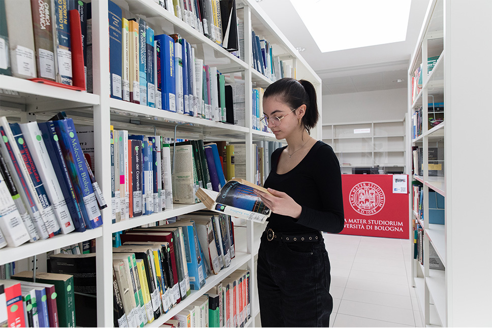 ragazza che legge tra gli scaffali
